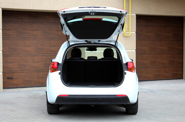 Modern wagon car with open empty trunk outdoors. White wagon car is ready to load luggage. Clean...