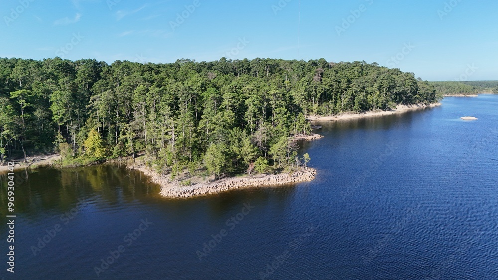 Wall mural Aerial view of a serene lake surrounded by forest.