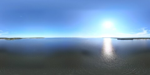 Panoramic view of a calm sea with a clear blue sky.