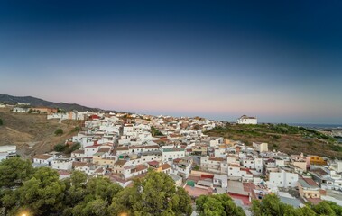 Obraz premium A scenic view of a hillside village with white houses under a clear twilight sky in Spain.