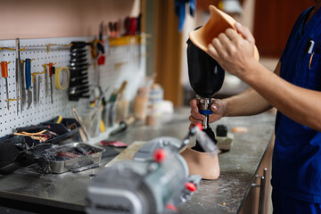 Technician assembling prosthetic leg in a workshop setting