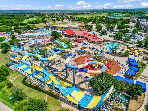 Aerial view of a busy water park with various slides, pools, and people enjoying summer activities