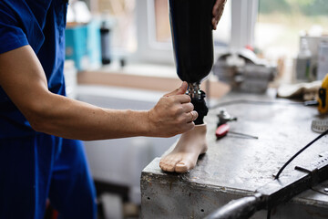 Technician adjusting a prosthetic leg in a workshop setting