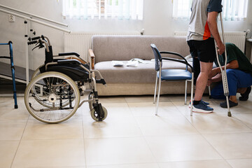 Physical therapy session with crutches and wheelchair in rehabilitation center