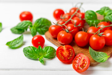 Fototapeta premium Fresh cherry tomatoes and fresh green basil on a textured background. Tomato sauce. Vegan. Ingredients for salad. Organic food. Place for text. Copy space.