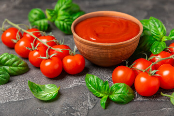 Fresh cherry tomatoes and fresh green basil on a textured background. Tomato sauce. Vegan. Ingredients for salad. Organic food. Place for text. Copy space.