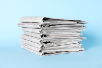 Stack of newspapers on light blue background