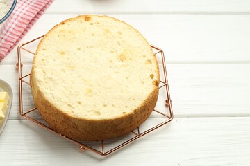 Tasty cut sponge cake on white wooden table, above view. Space for text