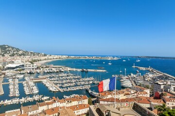 Obraz premium Panoramic view of Cannes harbor with boats and French flag