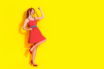 Full length photo of cheerful glad adorable lady wear stylish dress high heels celebrate holiday isolated on yellow color background