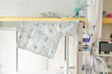 A surgical gown hangs in a hospital bed ready for a child receiving treatment.