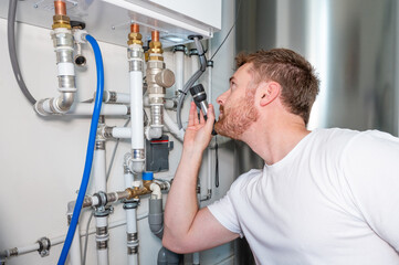 Technician adjusting a valve on a pipe from a heat pump