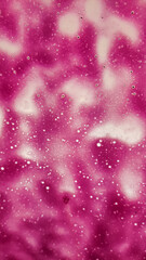 Magenta liquid forming abstract shapes with bubbles. Vertical mobile photo