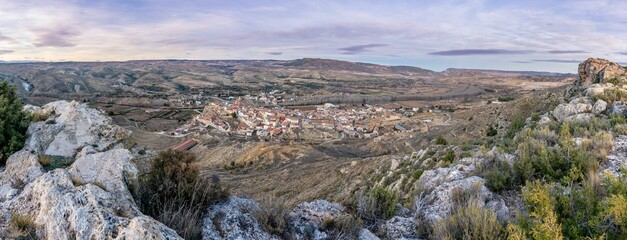 Panoramic view of a small town in a mountainous landscape.