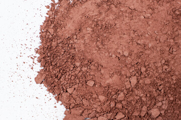 Scattered brown eyeshadow on a white background. Eye shadow texture