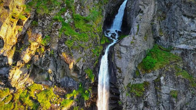 Drone view of Boafossen waterfall flowing on a rocky mountain, on a sunny day in Laerdal, Norway