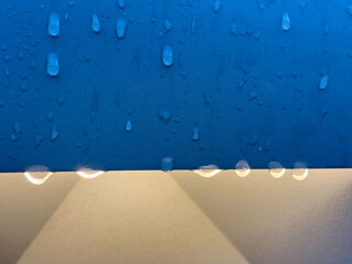 Raindrops on an outdoor light fixture in a botanical garden on a summer morning in southwest...