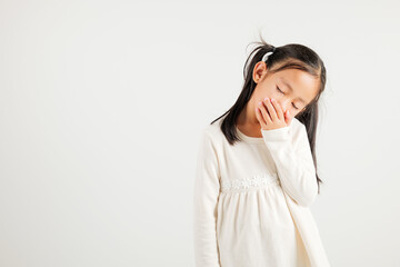 Portrait Asian young kid girl emotions tired and sleepy yawning covering mouth open by hand, studio shot isolated on white background, Thai kindergarten child insomnia concept with copy space