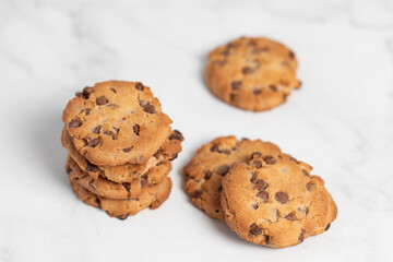 stacked chocolate chip cookies on white background