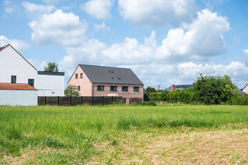 Obraz premium Farmhouses and farmland with harvested agriculture fields arould Holsbeek, Flanders, Belgium