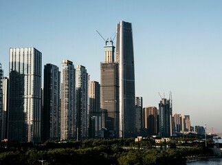 Fototapeta premium City skyline with high-rise buildings under construction on a clear day.