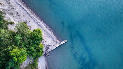 Aerial view of a tranquil beach and pier.