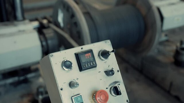 Process of winding cable onto a reel is being carried out in a cable factory