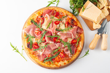 Pizza with prosciutto, ham, arugula, spinach, tomatoes, pesto, cheese and parmesan. Italian cuisine. 
