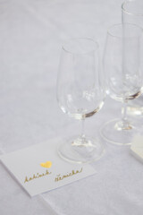 Wedding table with detail of glasses, cutlery and signs with name tags in the Czech language
