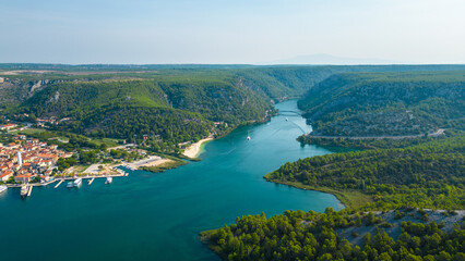 An aerial view of Skradin, a charming town near Krka National Park in Croatia. Nestled along the Krka River, the town features a picturesque marina filled with yachts and boats.