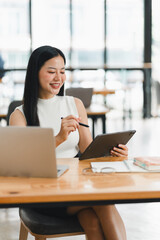 Obraz premium A woman is happily working on tablet in modern office space