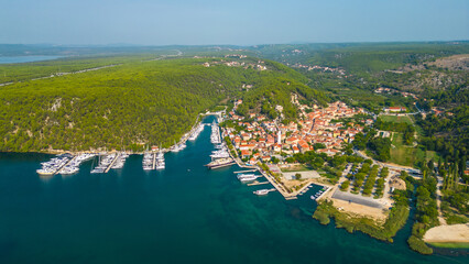 Fototapeta premium An aerial view of Skradin, a charming town near Krka National Park in Croatia. Nestled along the Krka River, the town features a picturesque marina filled with yachts and boats.