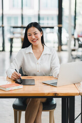 A confident woman working at modern office desk with laptop