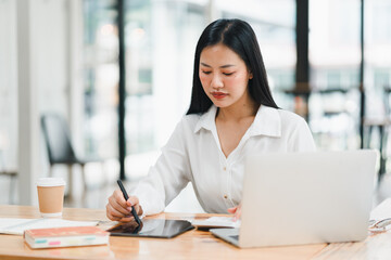 Focused woman working on tablet in modern office environment