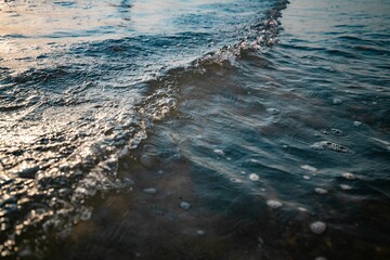 Beautiful view of gentle ocean waves lit by the golden hour natural light