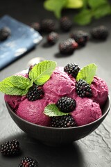 Delicious blackberry sorbet, fresh berries and mint in bowl on gray textured table