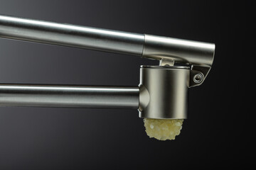 Garlic press on a black background.