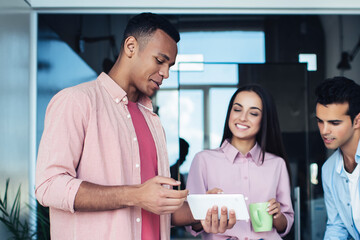 Happy colleagues in casual clothing enjoying online browsing and networking on modern digital tablet during work break form brainstorming on info for business project, concept of web technology