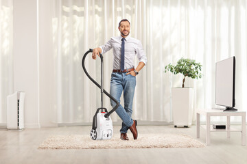 Man gesturing standing with a vacuum cleaner on a carpet