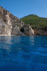 Vertical view of blue waters and coastal cliffs covered with green vegetation in Zakynthos, Greece