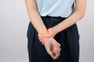 Obraz premium Wrist pain problem. Close up asian woman hold her pained wrist from work isolated on white background. office syndrome problem and healthcare concept.