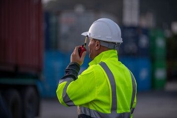 Engineer or worker standing forklift or truck vehicle are holding detail and appear to be discussing or reviewing documents, likely related to inspect about factory and industry worksite.