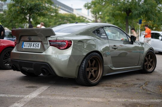 Toyota GT86, green with gold wheels. It has a rocket bunny style rear wing.