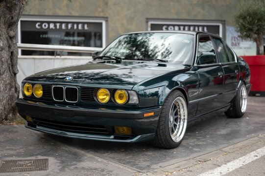 green BMW 5 series E34 520IS. Classic high-end German car tuned and with yellow headlights