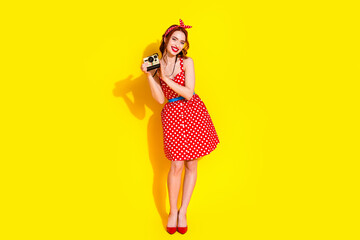 Photo of lovely pretty lady wear red stylish clothes hold camera take picture isolated on yellow color background