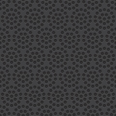 A textured pattern featuring repetitive abstract shapes in dark tones.