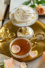 On the white table there is hot tea, cakes and delicate roses.