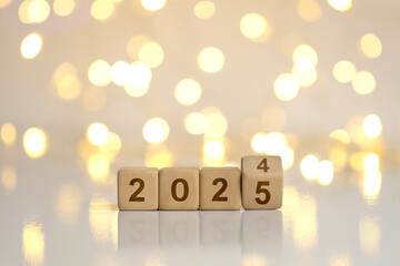 New Year Goals 2025. Flipping numbers 2024 to 2025 on a wooden block cube on a light bokeh...