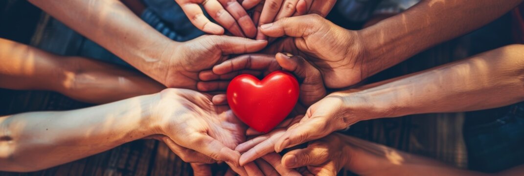 Naklejki Symbol of unity: diverse hands coming together to hold a red heart