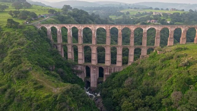 Aqueduct between mountains at sunrise with cloudy sky in arcos del sitio in tepotzotlan state of mexico